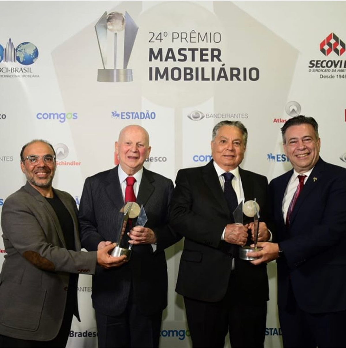 George Jalil with colleagues holding trophies at the Prêmio Master Imobiliário in Brazil
